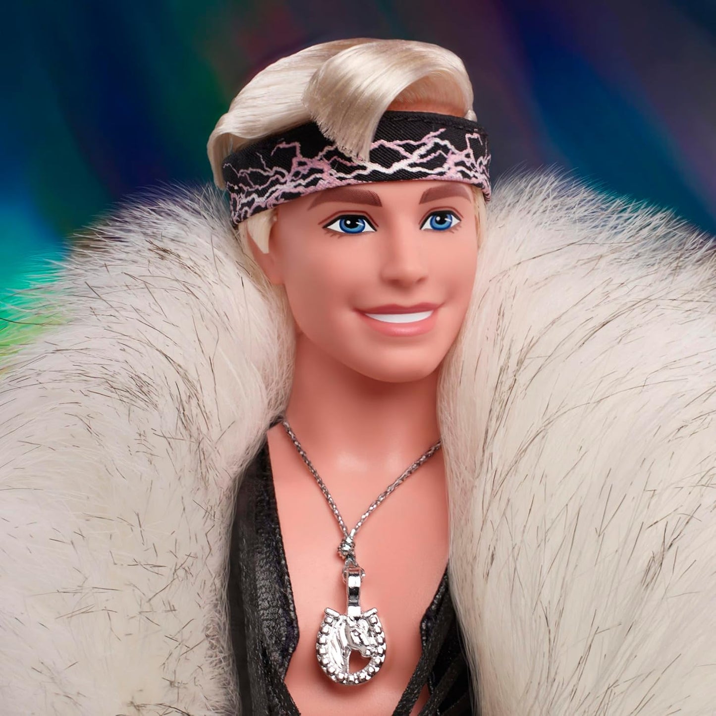 Barbie Boneco Ken colecionável do filme vestindo um grande casaco de pele falsa e colete preto com franjas e bandana, HRF31